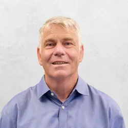 Dr. Shane White is wearing a blue collar shirt.