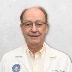 Dr. Morgan is wearing a white doctor's coat over a white shirt.