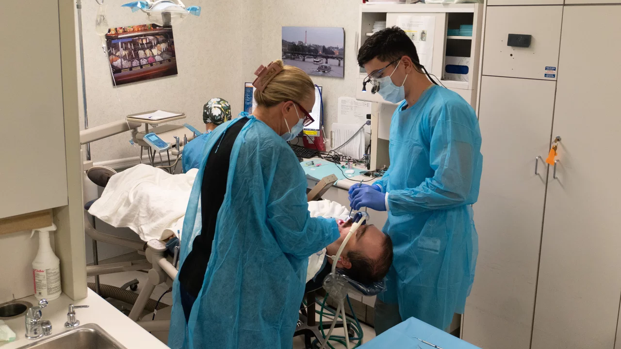 Two dentists working with a sedated patient