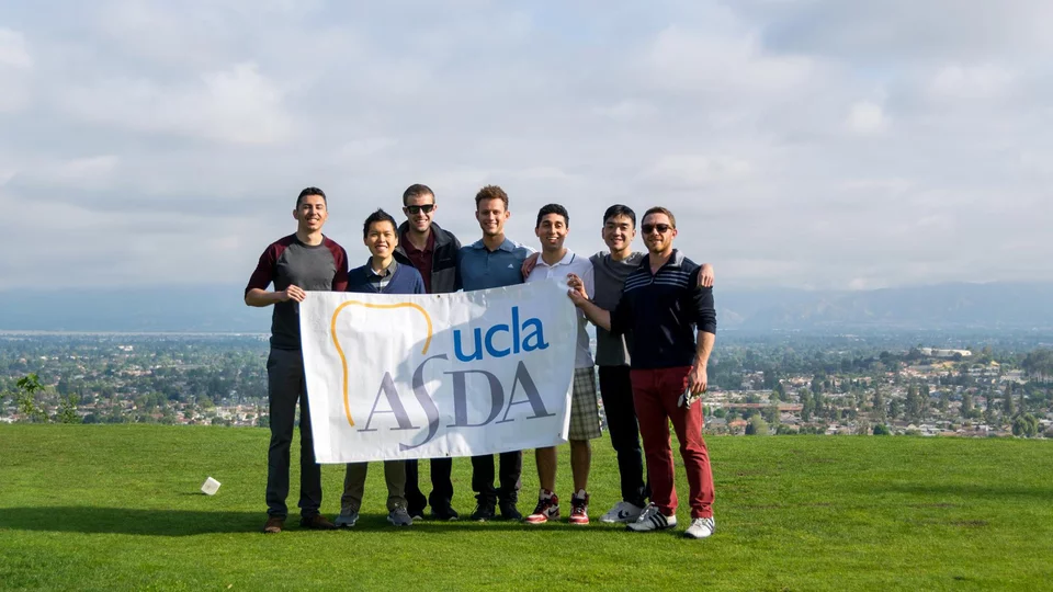 Students holding up sign at ASDA golf tournament