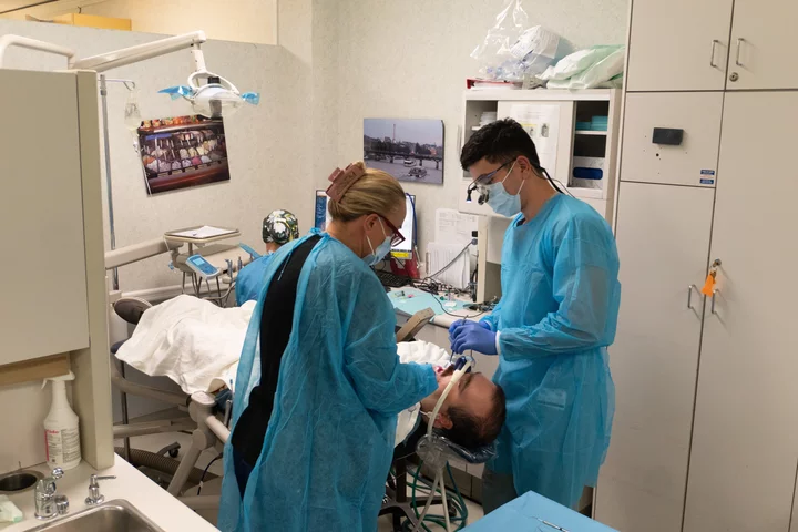 Two dentists working with a sedated patient
