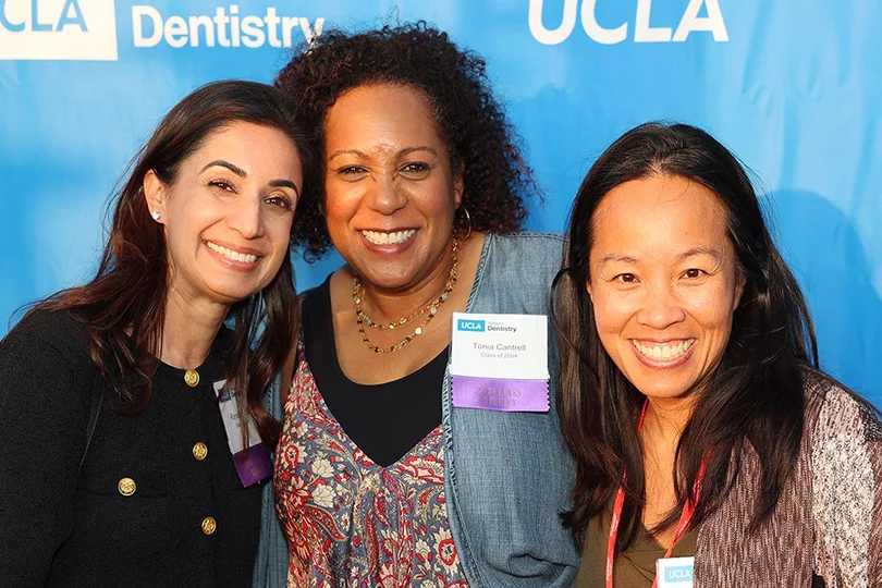 Three Alumni in a group picture at the 2024 Alumni Event