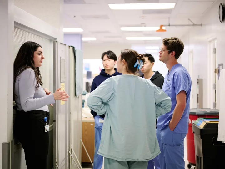 Social worker discussing with dental resident and dental students