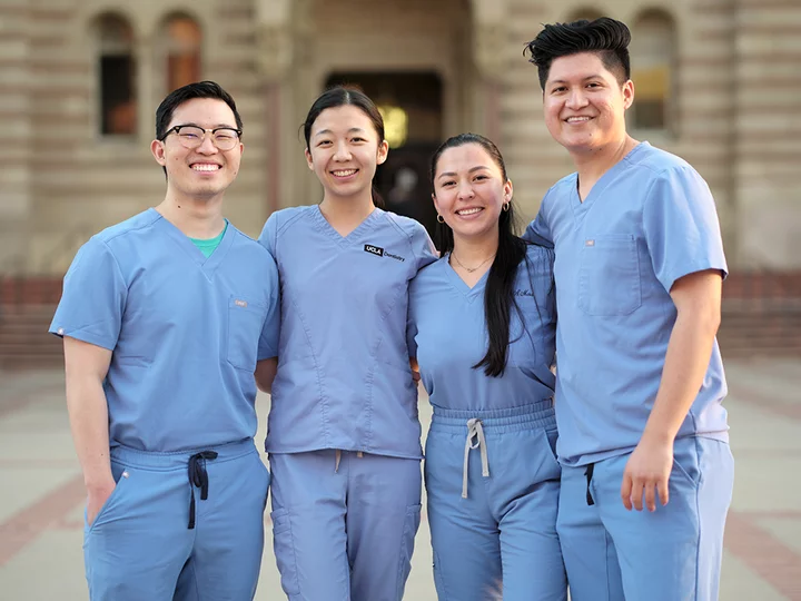 Three dental students in front of the Powell Building