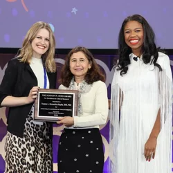 Dr. Yvonne Hernandez-Kapila receivubg an award from two people