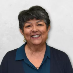 Janet Cicero is has short hair and is wearing a teal top.