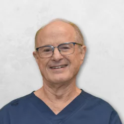Keith L. Radack is wearing glasses and a blue scrub top. 