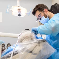 Dental student performing care on an elderly patient